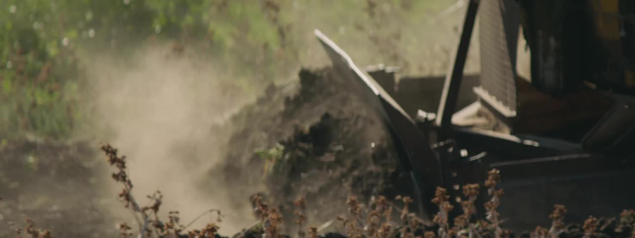 A tractor is moving dirt in a rural area