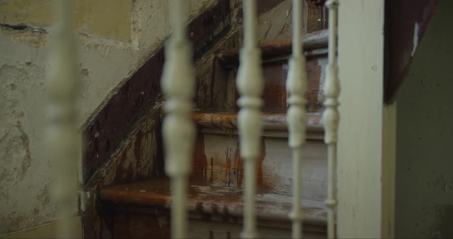 A banister with a staircase with dripping water