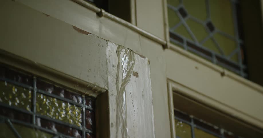 Water flows from joint in area between stained glasses windows