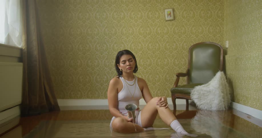 A woman sitting on the floor of a flooded living room