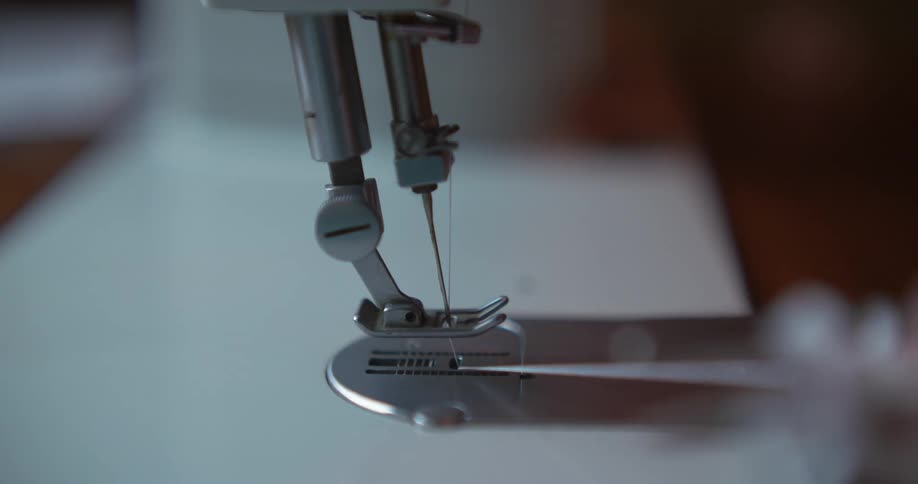 A person cutting thread on a sewing machine