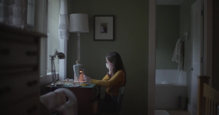 A young girl sewing face masks with a sewing machine