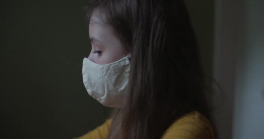 Girl adjusts cloth face mask before moving her face around to check fit