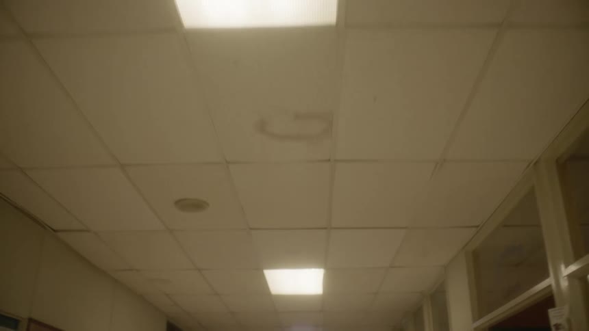 Lights dot the ceiling of an industrial looking building