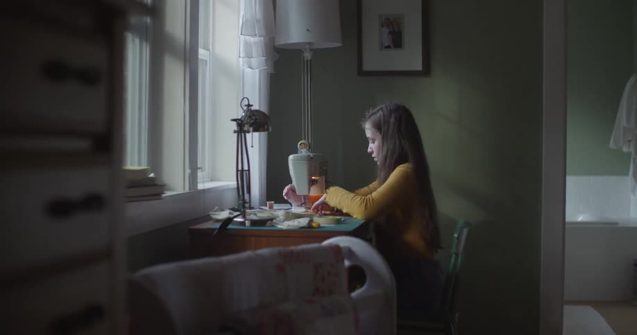A woman is stitching close at home