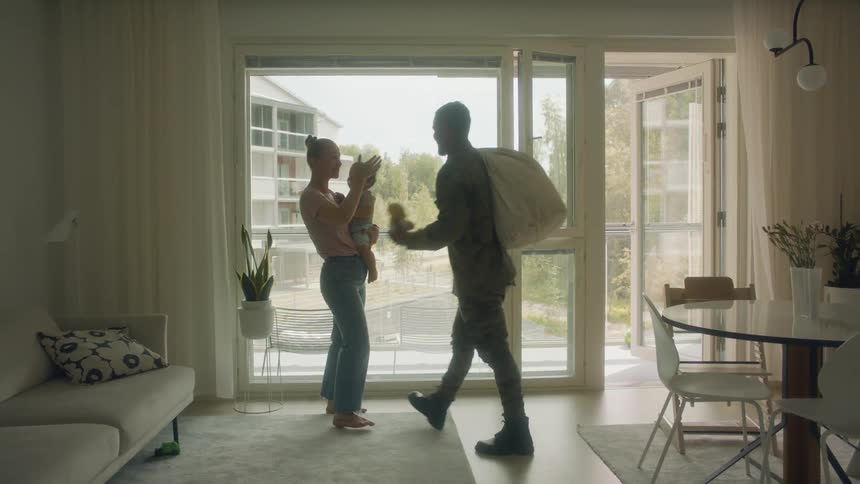 A soldier enters the house and hugs his family