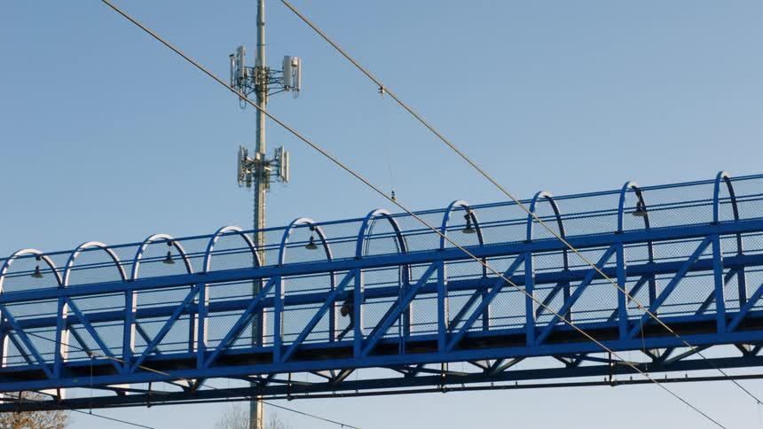 A man walks on the overpass on a sunny day