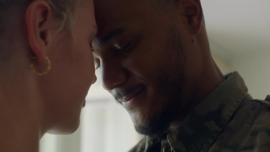 A man and woman are standing facing each other with their foreheads touching