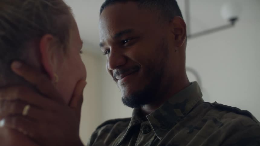 A couple is facing each other and the man is holding the womans face