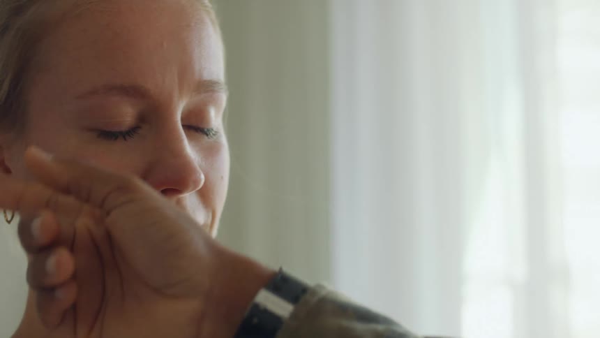 A man wiping tears off of a womans face