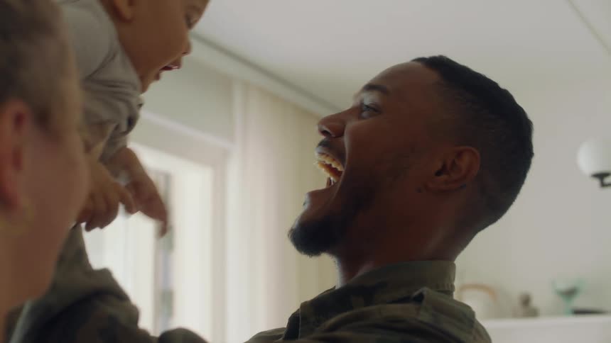 Mother and father kissing before picking up son