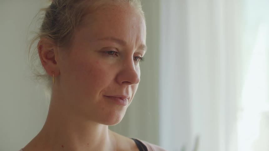A woman holds back tears after she embraces a man in a military uniform