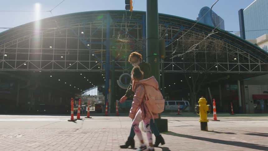 Woman and child walking down a city street