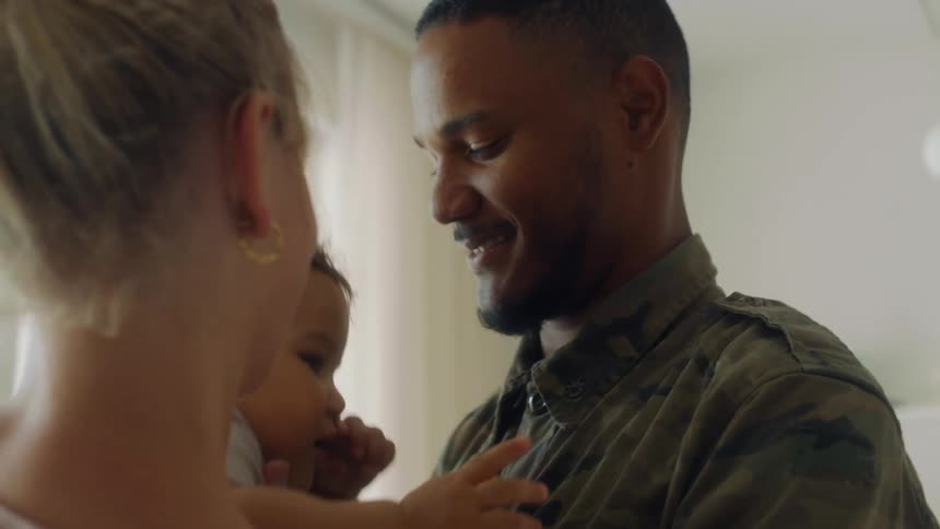 A man hugs his daughter at home