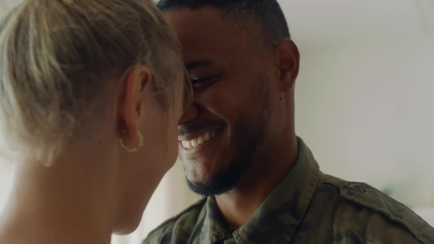 A man and woman are smiling at each other and kiss