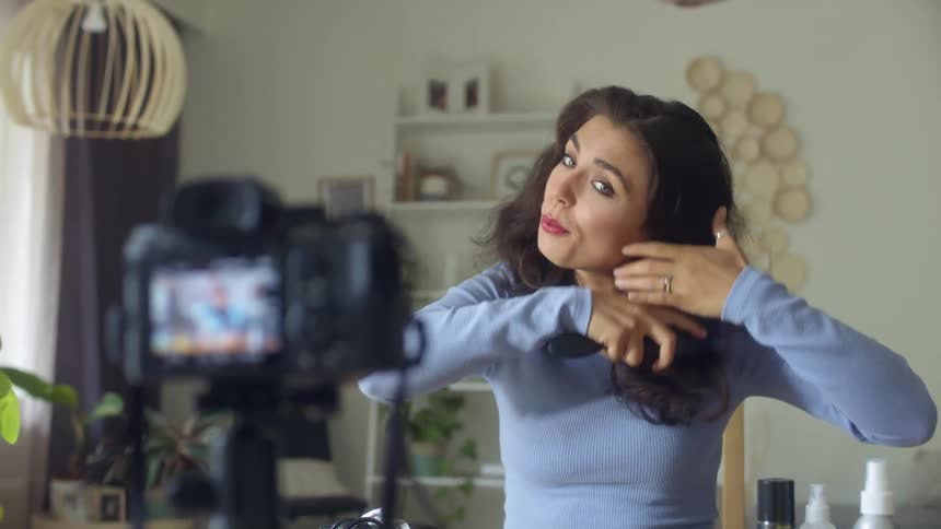 A woman brushing her hair on camera