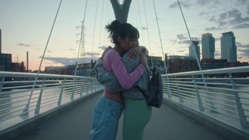 Two women hugging each other outdoors