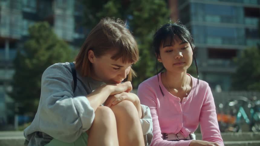 Two women sitting outside talking with each other