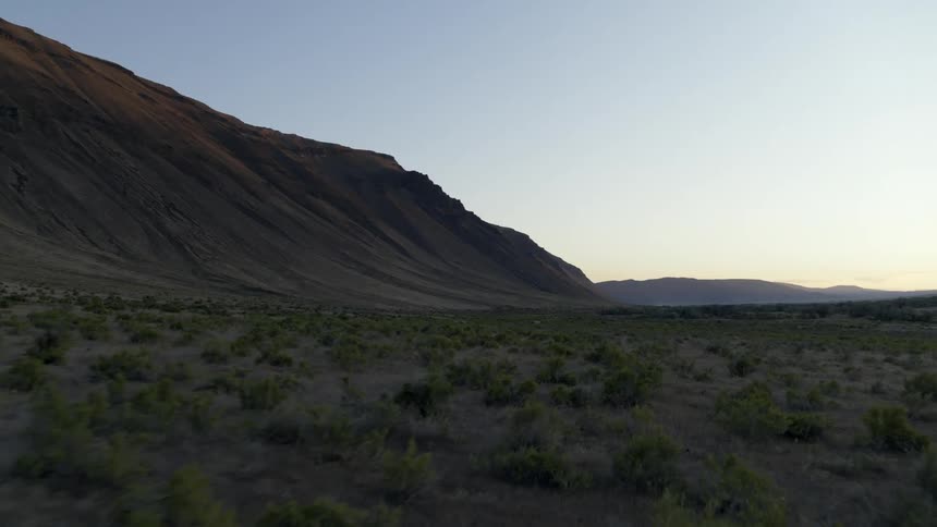 Low skim over scrub and sagebrush along a beautiful mountainside slope at dusk