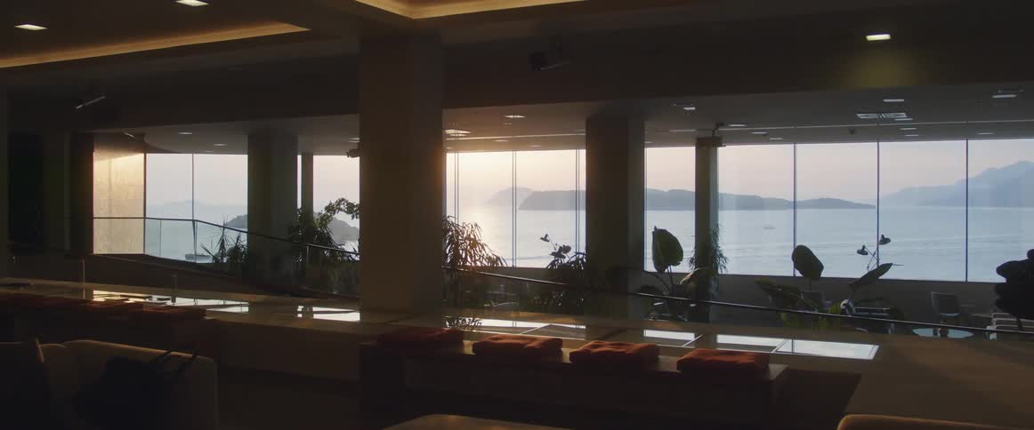 The sun is rising through the window of the dark office