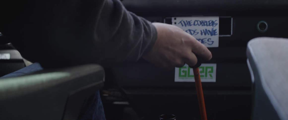 A man pushes a stick shift in a vehicle