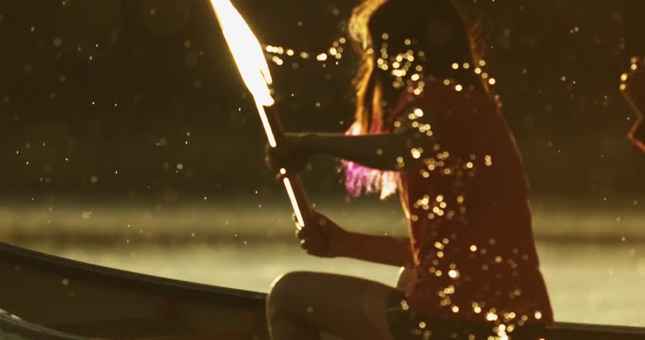 Young girl rowing a kayak on a lake under the rain at sunset