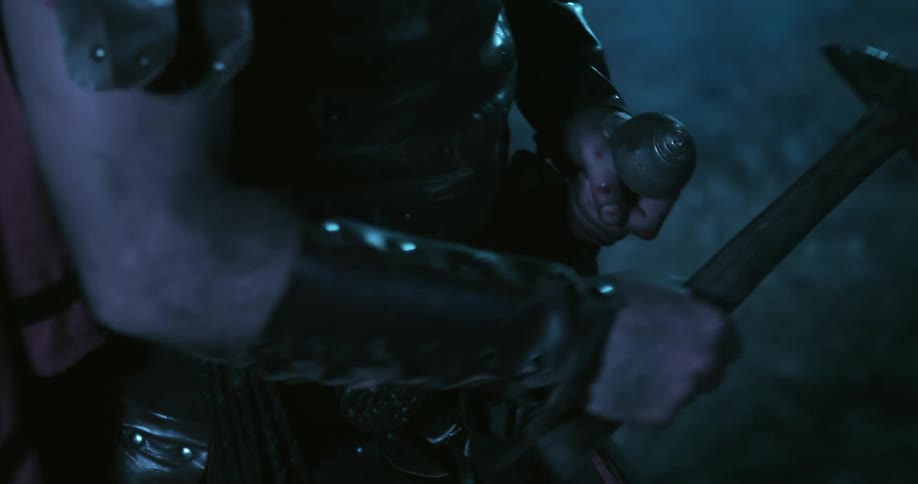 A man wearing armor is holding a weapon
