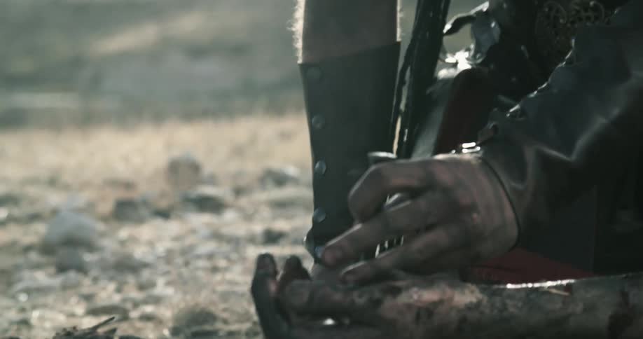 A man prepares to drive a stake into another mans hand