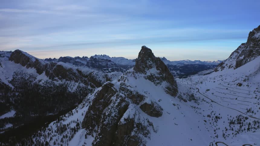 An aerial view of snowy mountains at dusk