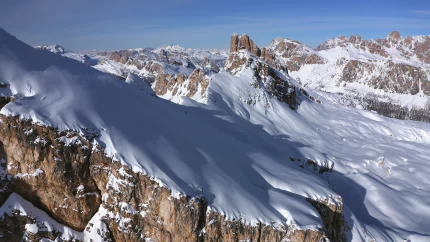 Snow covered mountains with peaks high in a blue sky