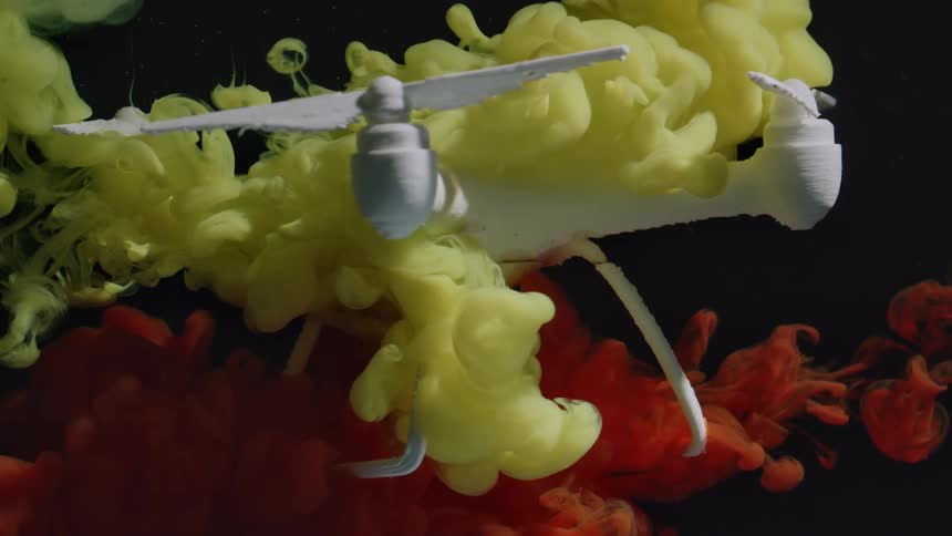Colored clouds of liquid cover the plastic drone underwater