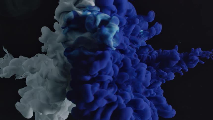 A white lightbulb is covered with white and blue ink underwater