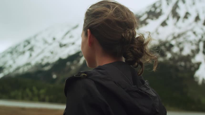 A woman looks back and forth at the mountain