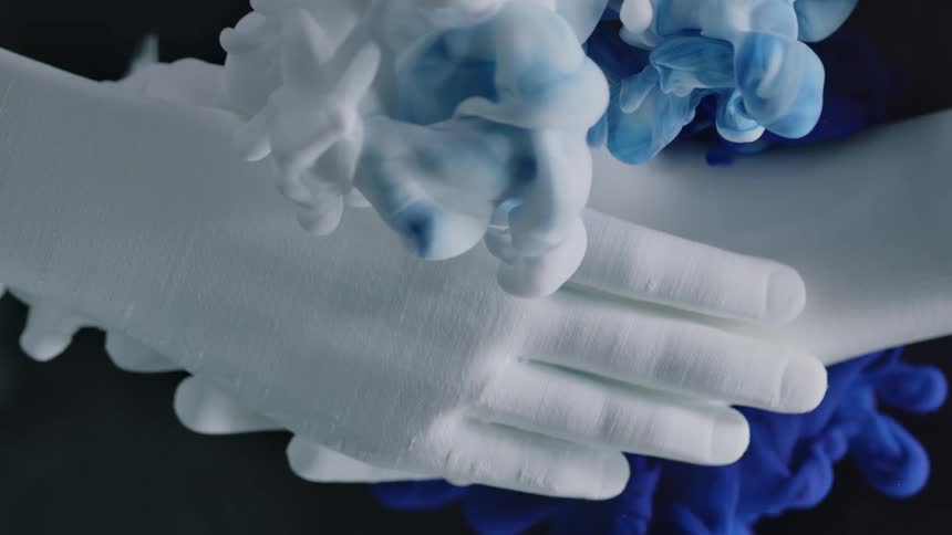 Hands clasp together as a smoky gel substance oozes around them