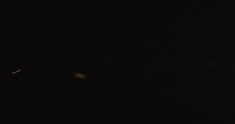 Particles streak by against black background