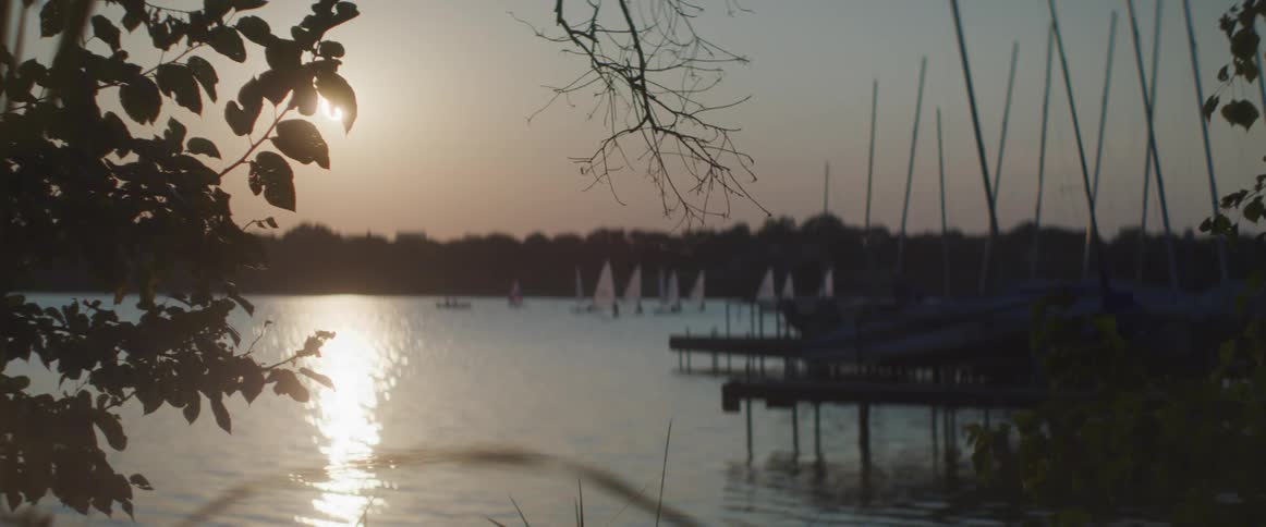 Boats sit motionless in the water near piers