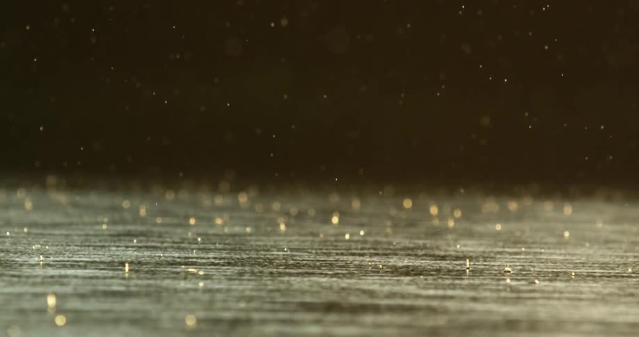 Raindrops fall on lake as the sun shines