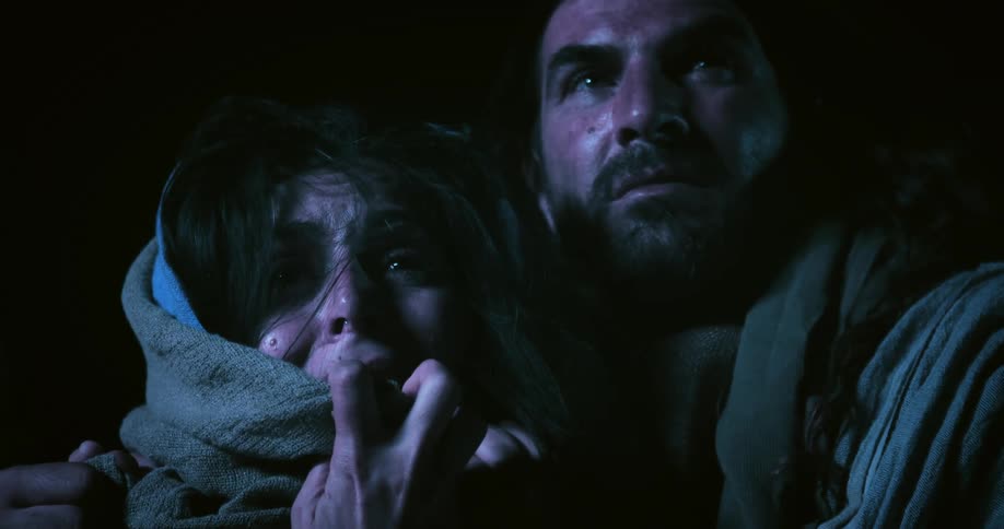 Man consoling a sad crying woman wearing a robe at night