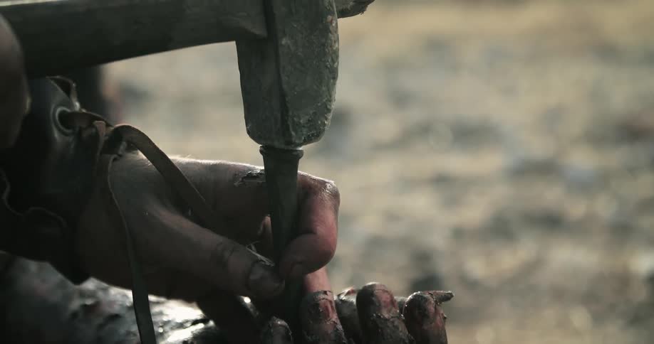 A person is hammering a spike into someones hand