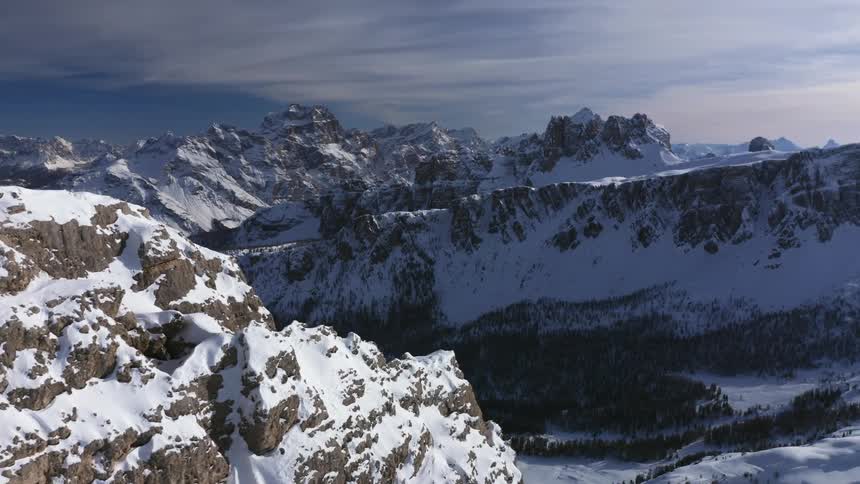 Snow covered mountains with peaks high in a cloudy sky