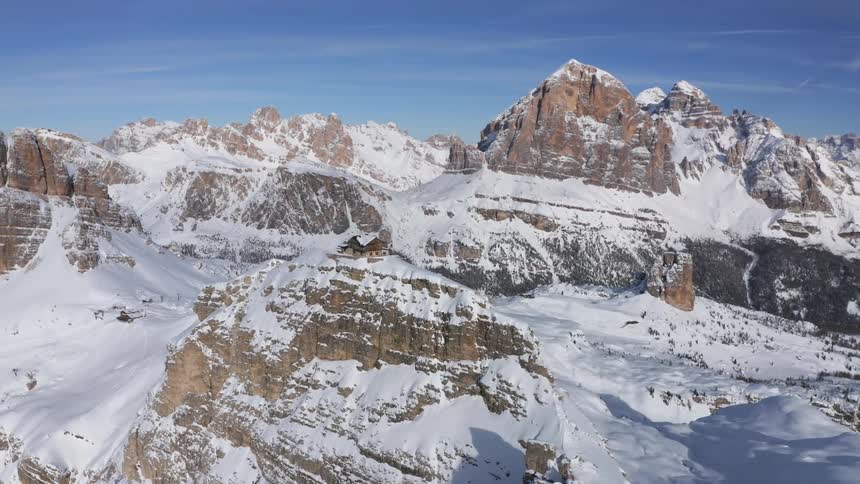 A building on the top of a narrow mountain ridge under a clear sky