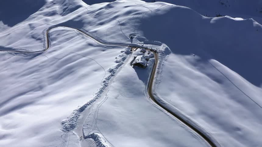 House on a winding road on a snow covered mountain