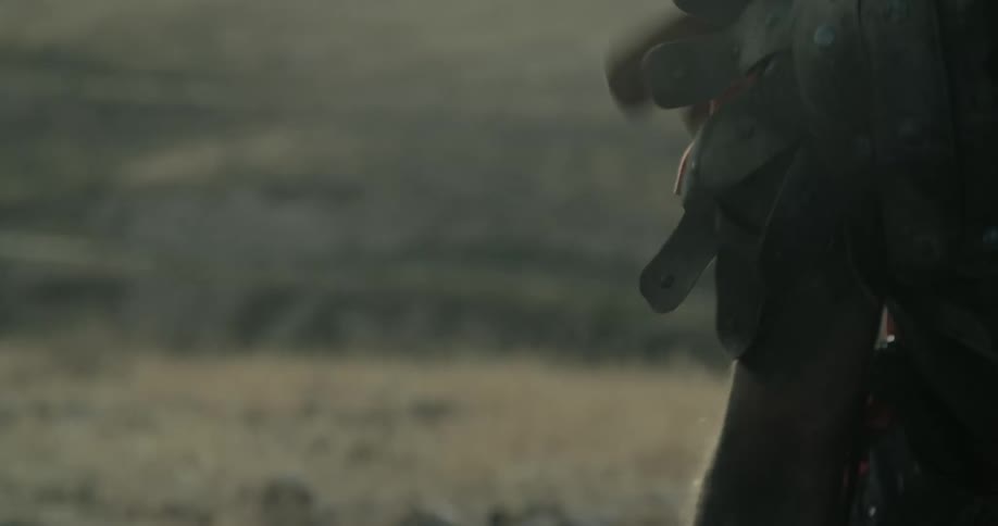 A person lowers their arms near the mountain