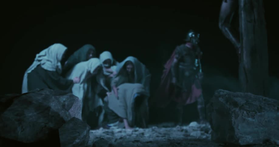 A roman soldier and people at the foot of the cross with an earthquake