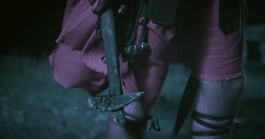 Soldier wearing ancient armor bleeds as he holds hammer with blood on it