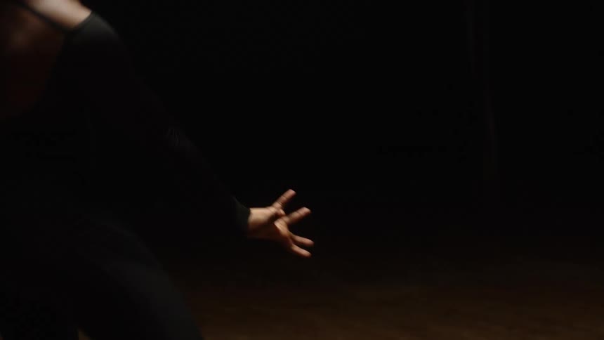 A woman is moving around and dancing in tights