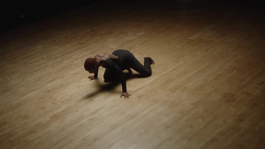 A woman is dancing under the spotlight
