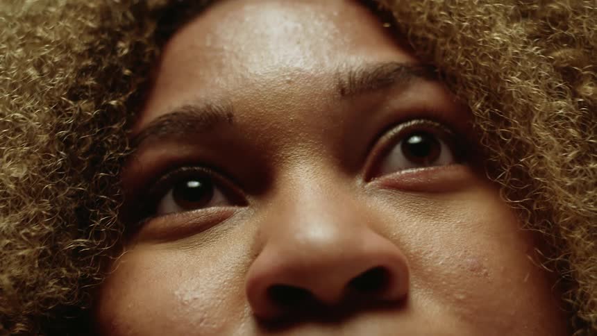 Close up of womans face with brown curly hair