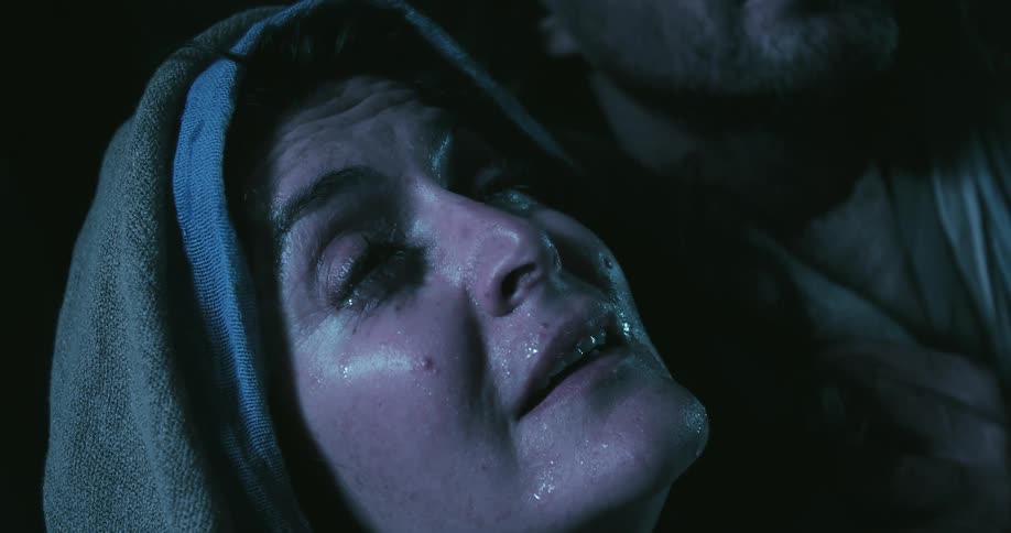 Water droplets drops on the face of a woman as she looks upwards