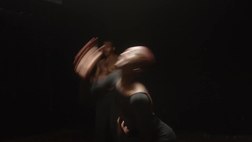 Male and female dancers dance individually on dark wooden stage under stage light
